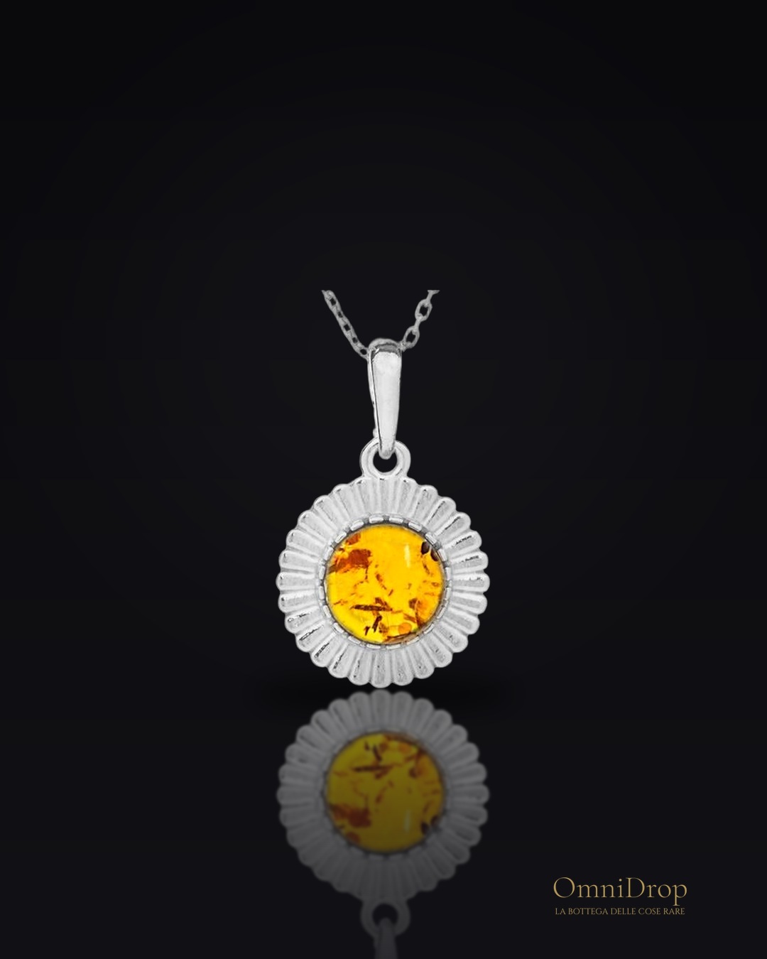 Ciondolo sole in argento rodiato con ambra cognac, per custodire la luce interiore